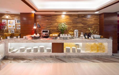 a lobby with a store with a counter with white jars at Winsuites Saigon Hotel in Ho Chi Minh City