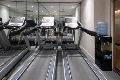 a row of treadmills on a treadmill in a gym at Winsuites Saigon Hotel in Ho Chi Minh City