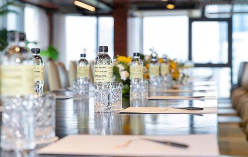 a long table with bottles and glasses on it at Winsuites Saigon Hotel in Ho Chi Minh City
