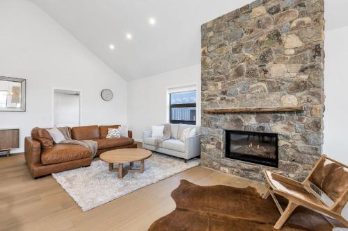 a living room with a stone fireplace at 14 Abbott Street - House in Jindabyne