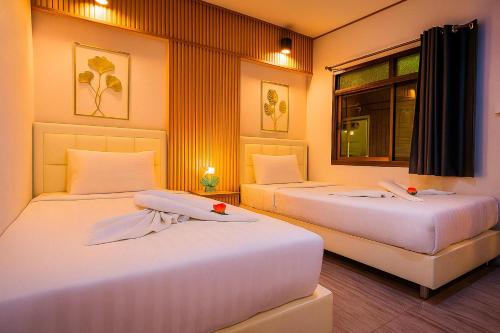 two beds sitting in a room with a window at Eclipse Hostel and Bar in Haad Rin
