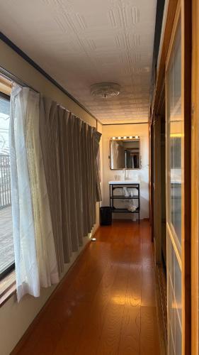 a room with a hallway with curtains and a kitchen at 自然に囲まれた海沿いの広い一軒家 貸切 佐渡 古民家 レッドジャスパーRedjasper in Sado
