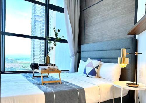 a bedroom with a large bed with a large window at Atlantis Residences Melaka in Melaka