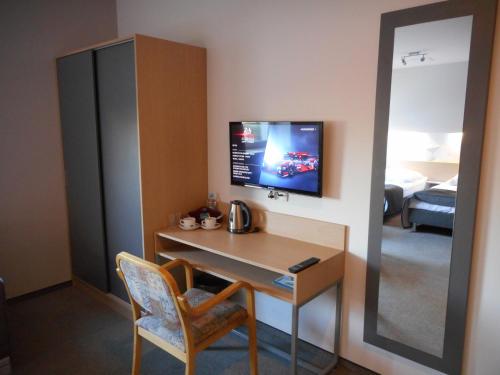 a room with a desk and a tv on a wall at Hotel Platan in Ostrów Wielkopolski