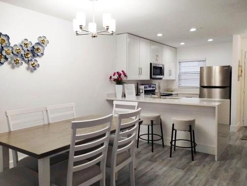 a kitchen with a dining table and a kitchen with white cabinets at Family Townhouse with Waterpark - Minutes from Disney in Kissimmee