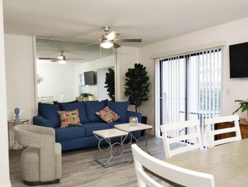a living room with a blue couch and a table at Family Townhouse with Waterpark - Minutes from Disney in Kissimmee