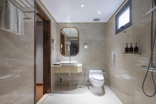 a bathroom with a toilet and a sink and a shower at Winsuites Saigon Hotel in Ho Chi Minh City