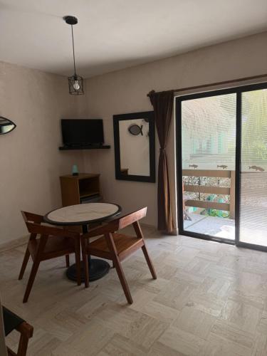 a living room with a table and a window at Hotel Villas Tiburon Adults Only in Holbox Island