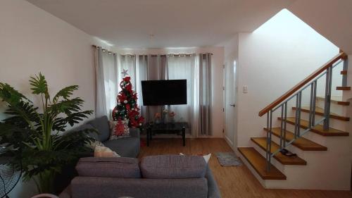 a living room with a christmas tree and a couch at Avida 3-Bedroom Vacation House with Pool in Minuluang