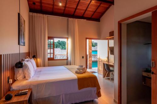 a bedroom with a bed and a desk and a window at Vila Diamantina in Mucugê