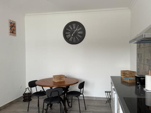 a kitchen with a table and a clock on the wall at Casa Colorida in Reguengos de Monsaraz