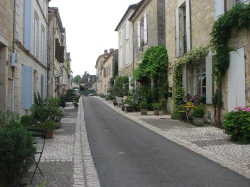 an empty street with buildings and potted plants at Duplex Carreyrou in Beaumont-du-Périgord