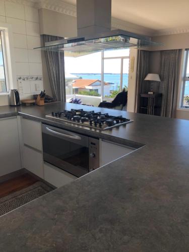 a kitchen with a stove and a counter top at Coppelia Sunrise in Omokoroa