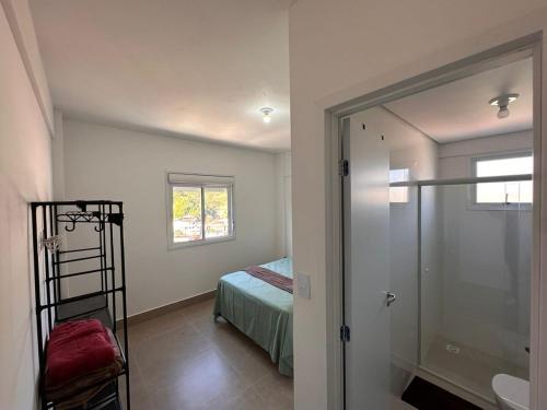 セーハ・ネグラにあるApartamento centro da cidade com garagemのベッドのある寝室とシャワー付きのバスルーム