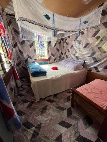 a bedroom with two beds in a room with a wall at Tai Bee Homestay in Soso
