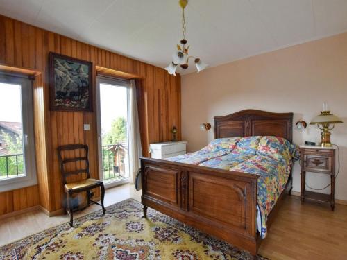 a bedroom with a bed and a chair and windows at Appartement à Neuvecelle avec balcon, parking et vue lac - FR-1-498-119 in Neuvecelle
