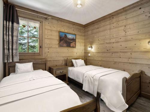 two beds in a room with wooden walls at Chalet indépendant avec sauna et parking à Courchevel 1650 - 8 pers - FR-1-563-162 in Courchevel
