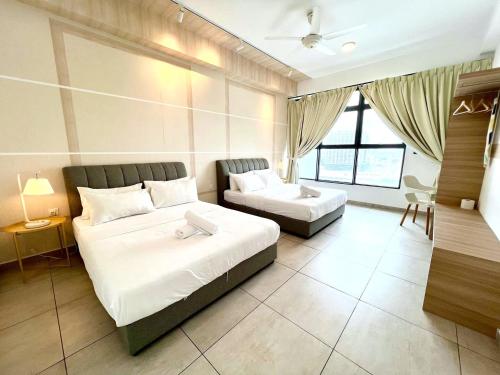 a hotel room with two beds and a couch at Atlantis Residences Melaka in Melaka
