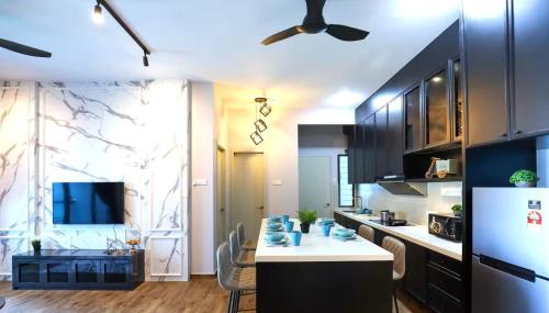 a kitchen with black cabinets and a white counter top at Atlantis Residences Melaka in Melaka