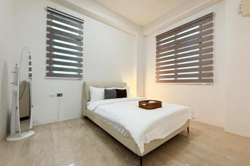 a white bedroom with a bed and two windows at 慢慢三星民宿 ChillaxSanxing B&B in Sanxing