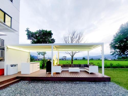 a pavilion with a couch and chairs on a wooden deck at 慢慢三星民宿 ChillaxSanxing B&B in Sanxing