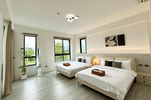 a bedroom with two beds and two windows at 慢慢三星民宿 ChillaxSanxing B&B in Sanxing