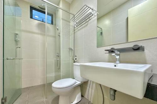 a bathroom with a sink and a toilet and a mirror at Atlantis Residences Melaka in Melaka