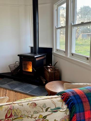 a living room with a fireplace and a couch at Beltane Cottage in Canyon Leigh