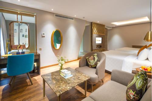 a hotel room with a bed and a desk at Winsuites Saigon Hotel in Ho Chi Minh City