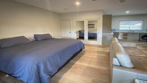 a bedroom with a large bed and a couch at Just For 2 - A Fantastic Apartment - Perfect Coffin Bay Base For One or Two Guests in Coffin Bay