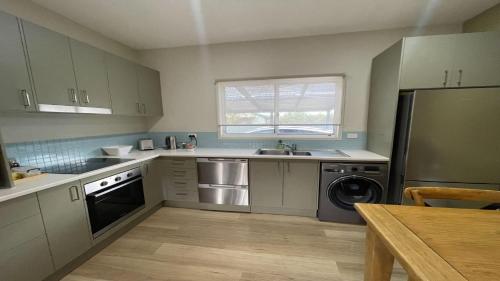 a kitchen with a sink refrigerator and a dishwasher at Just For 2 - A Fantastic Apartment - Perfect Coffin Bay Base For One or Two Guests in Coffin Bay