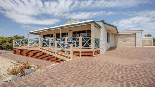 a house on a brick driveway with a garage at Catch of the Bay in Coffin Bay