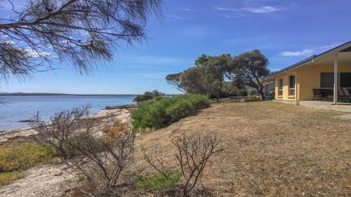 a house on the shore of a body of water at The Beach House - Spectacular Location - Privacy - Right On The Beach in Coffin Bay
