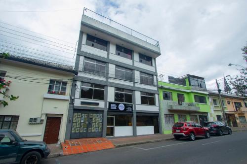 a building on a street with cars parked in front of it at Tin House Quito in Quito