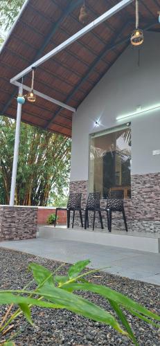 three benches sitting on a patio under a building at Bekal Village Homestay in Kāsaragod