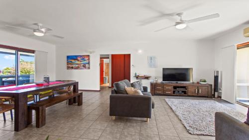 a living room with a dining table and a television at Casa De Praia Coffin Bay in Coffin Bay