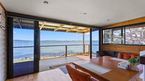 a dining room with a table and a view of the ocean at Kellidie Bliss Is Coffin Bay's Touch Of Paradise - Perfect Couples Retreat in Coffin Bay