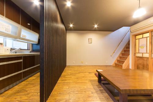 a kitchen and dining room with a table and a staircase at Nagomi Ryokan Yu - Vacation STAY 81037v in Kyoto