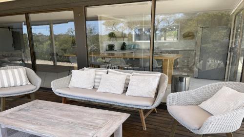 ein Wohnzimmer mit zwei Stühlen und einem Tisch in der Unterkunft No. 10 Coffin Bay in Coffin Bay