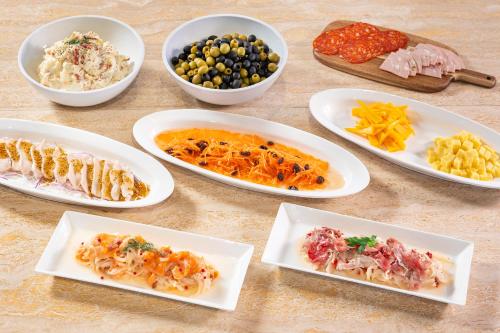 a table with plates of food and bowls of food at Candeo Hotel Utsunomiya in Utsunomiya