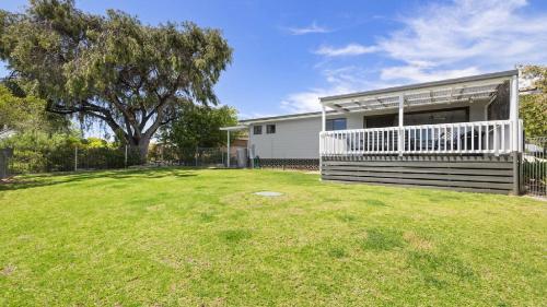 a house with a large yard with a tree at Endymion Is Ideally Situated On The Esplanade in Coffin Bay