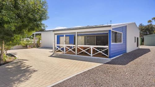 a large blue and white building with a fence at The Boathouse in Coffin Bay