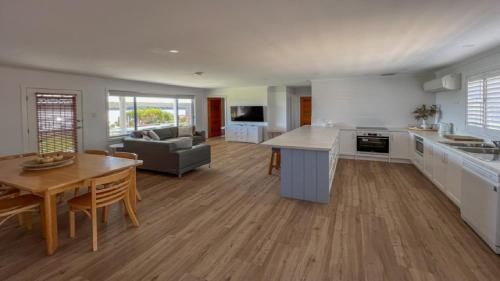 a large kitchen and living room with a table and chairs at Wrightaway in Coffin Bay