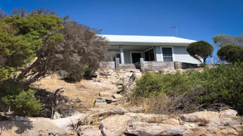 a white house on top of a hill with trees at Wrightaway in Coffin Bay