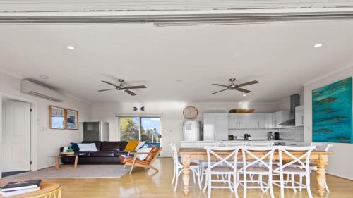 a kitchen and living room with a table and chairs at Endeavour View Is A Fantastic - A Modern, 4 Bedroom Holiday Home in Coffin Bay