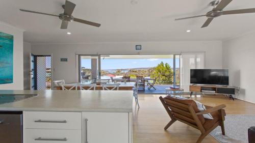 a kitchen and living room with a view of a living room at Endeavour View Is A Fantastic - A Modern, 4 Bedroom Holiday Home in Coffin Bay