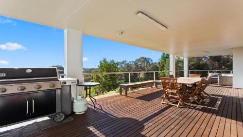 a patio with a grill and a table on a deck at Endeavour View Is A Fantastic - A Modern, 4 Bedroom Holiday Home in Coffin Bay