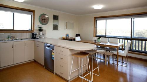 a kitchen with a counter and a table and chairs at Bay Life - Relax, Unwind andeexperience Coffin Bay Life At Its Best! in Coffin Bay