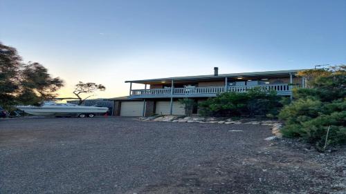 a large house with a boat parked in the driveway at Bay Life - Relax, Unwind andeexperience Coffin Bay Life At Its Best! in Coffin Bay