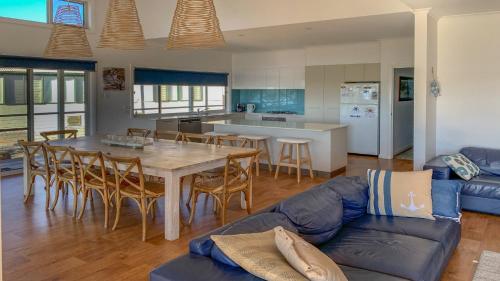 a kitchen and living room with a table and a couch at Angasi Is One Of Coffin Bay's Premium Properties - With Free Wifi in Coffin Bay